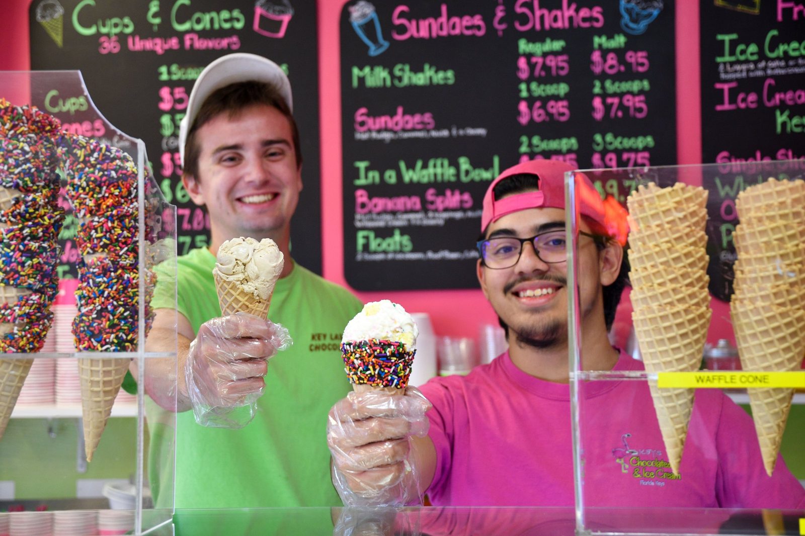 Two Keys Chocolates team members behind the counter holding ice cream cones