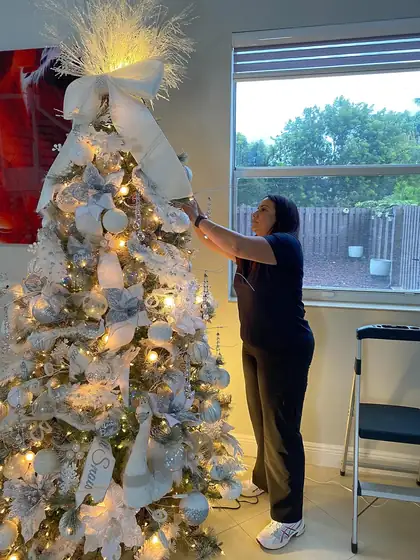 A Rose Art and Decor designer working on a white flocked tree