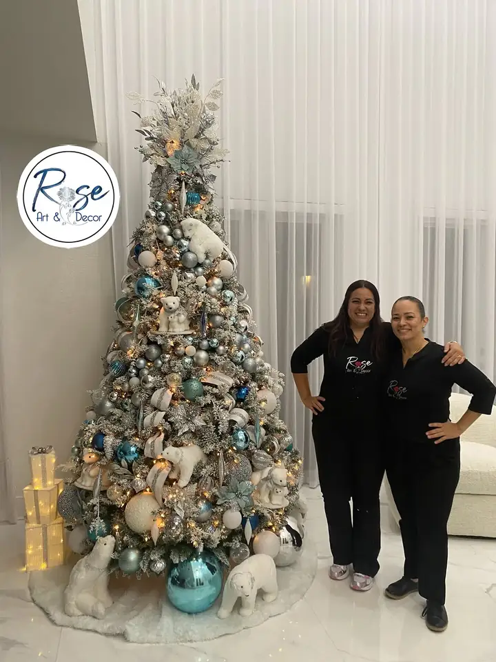 Two members of the Rose Art and Decor team standing beside a finished silver and blue Christmas tree