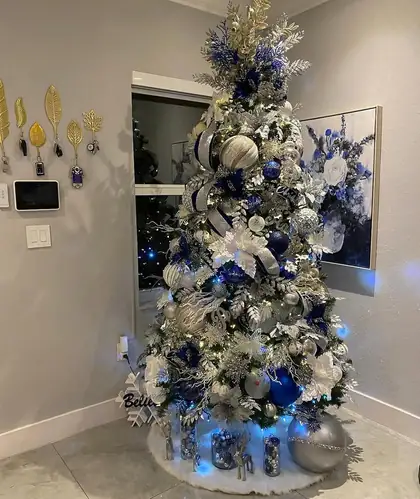 Blue and silver tree glowing in a neutral Miami room